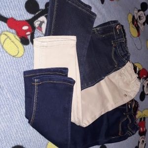 Two pair of blue jean pants and a pair of khaki pa